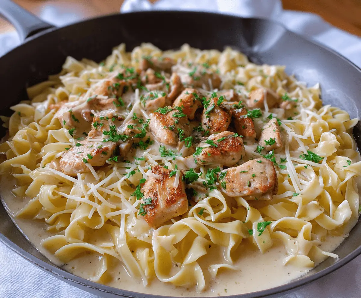 Delicious chicken served with creamy buttered noodles on a plate, garnished with herbs, perfect for a comforting meal