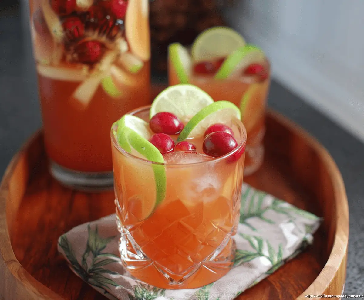 Colorful glass of Harvest Rum Punch garnished with fresh fruit slices, featuring vibrant orange, pineapple, and cherry accents, perfect for festive celebrations.