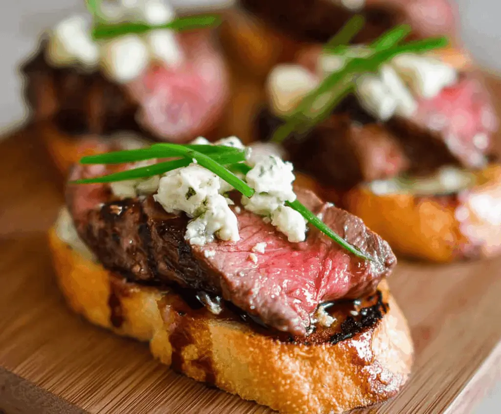 Delicious Beef Tenderloin Gorgonzola Crostini served as an appetizer with melted cheese and tender beef on toasted bread.