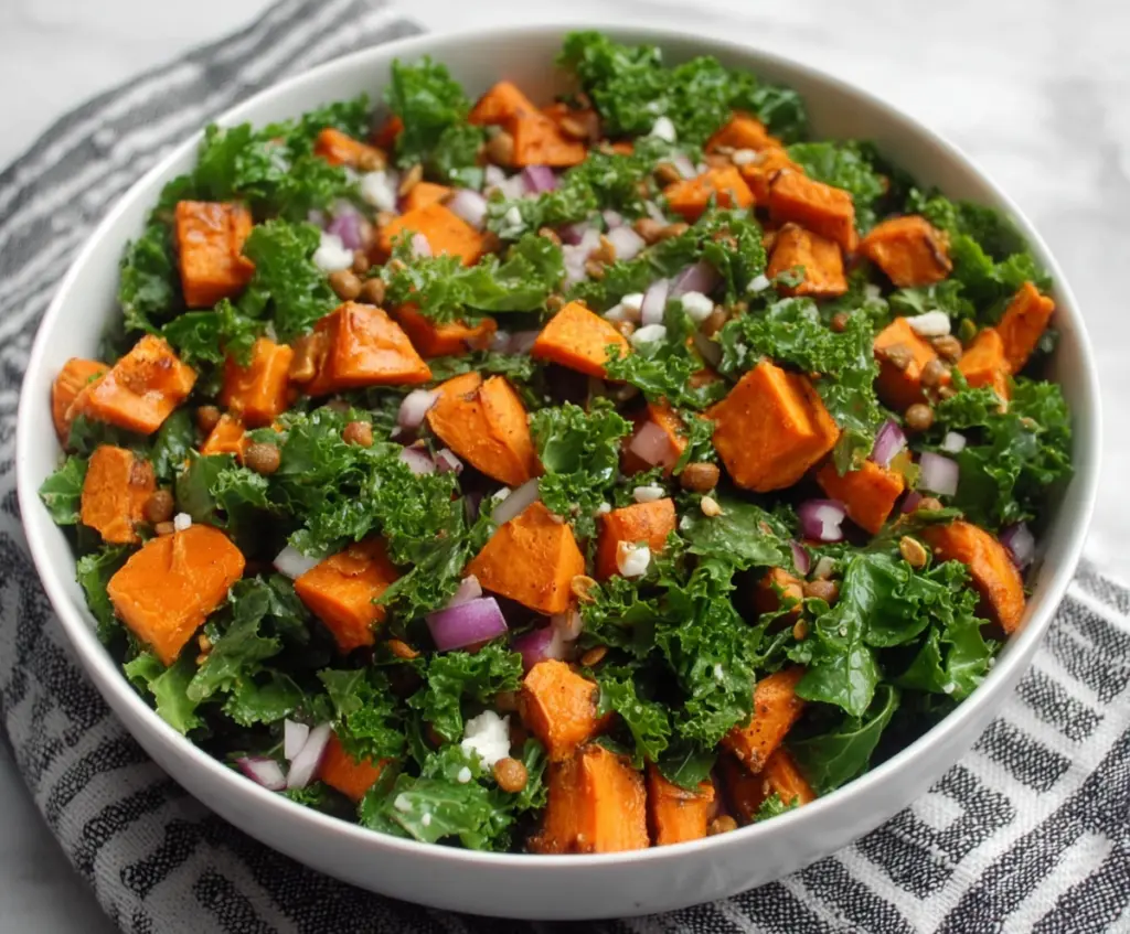 Fresh kale and roasted sweet potato salad with colorful vegetables and a light vinaigrette.