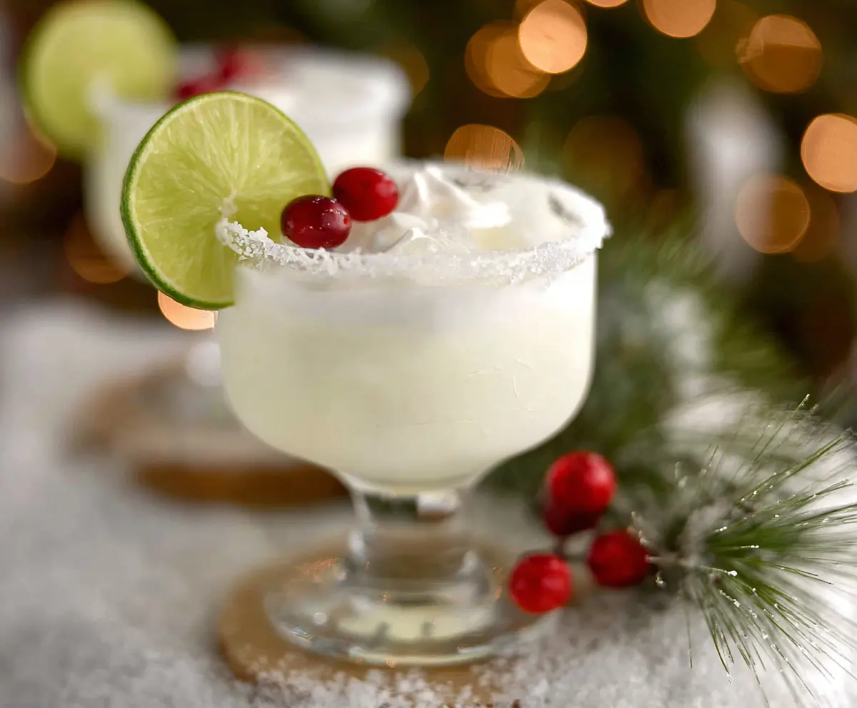 Refreshing White Christmas Margarita in a glass garnished with a lime wedge, perfect for holiday celebrations