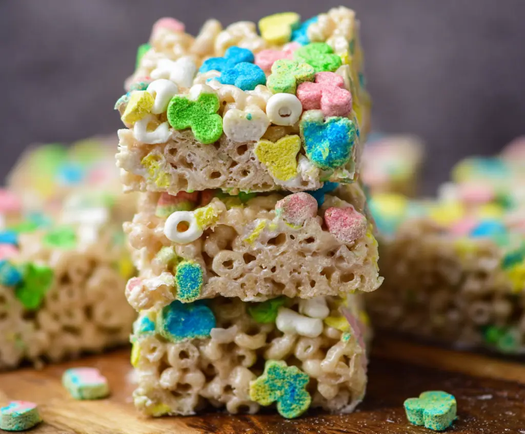 Colorful Lucky Charms Rice Krispie Treats featuring marshmallow cereal bars on a white platter