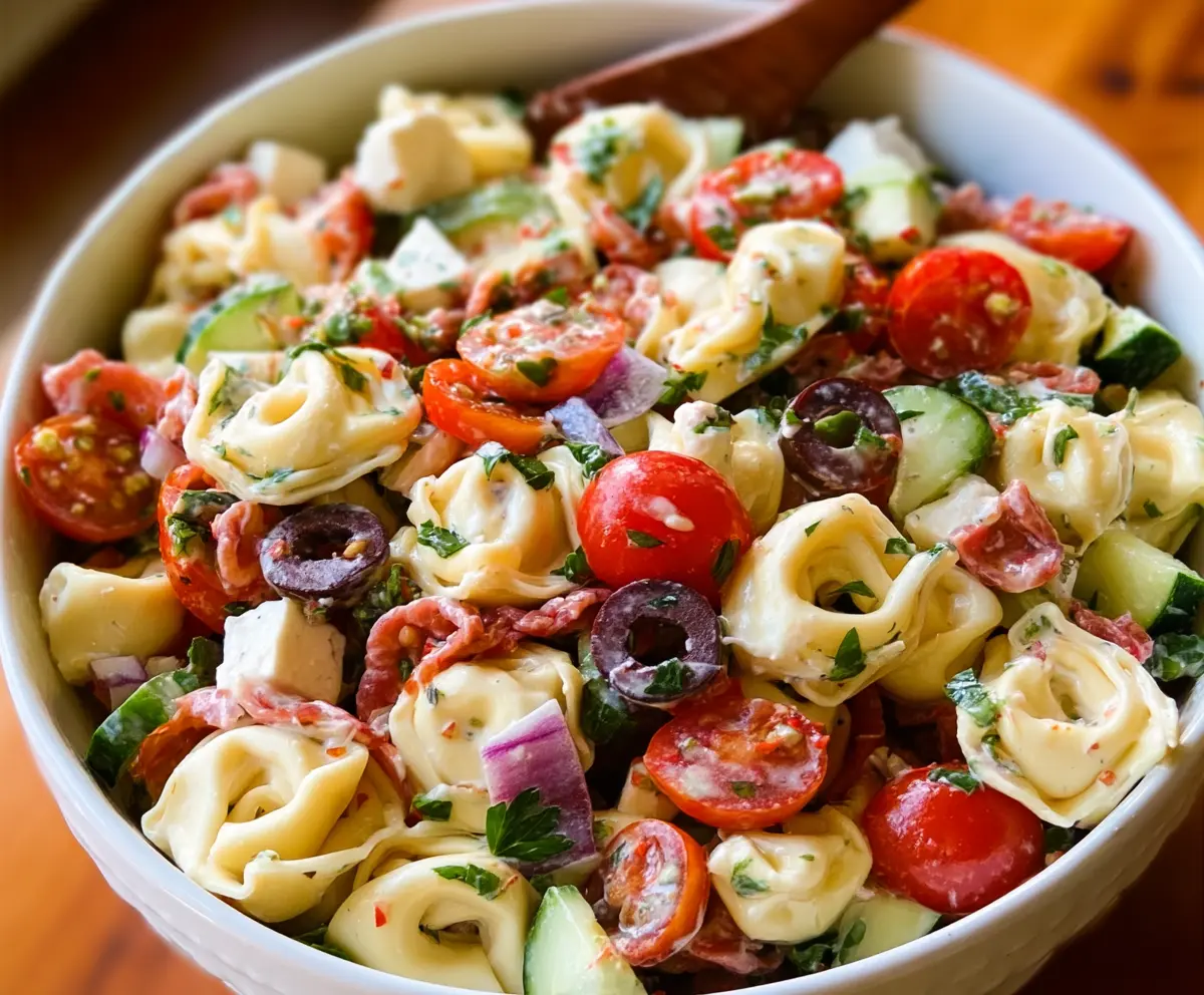 Colorful tortellini pasta salad with fresh vegetables and herbs, perfect for a quick lunch or picnic.